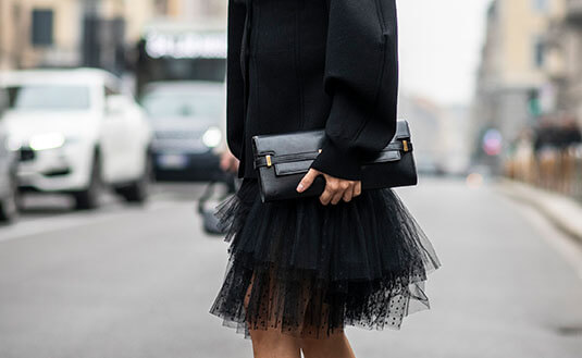 Schwarze Clutch mit schwarzem Blazer und schwarzem Tüll-Rock