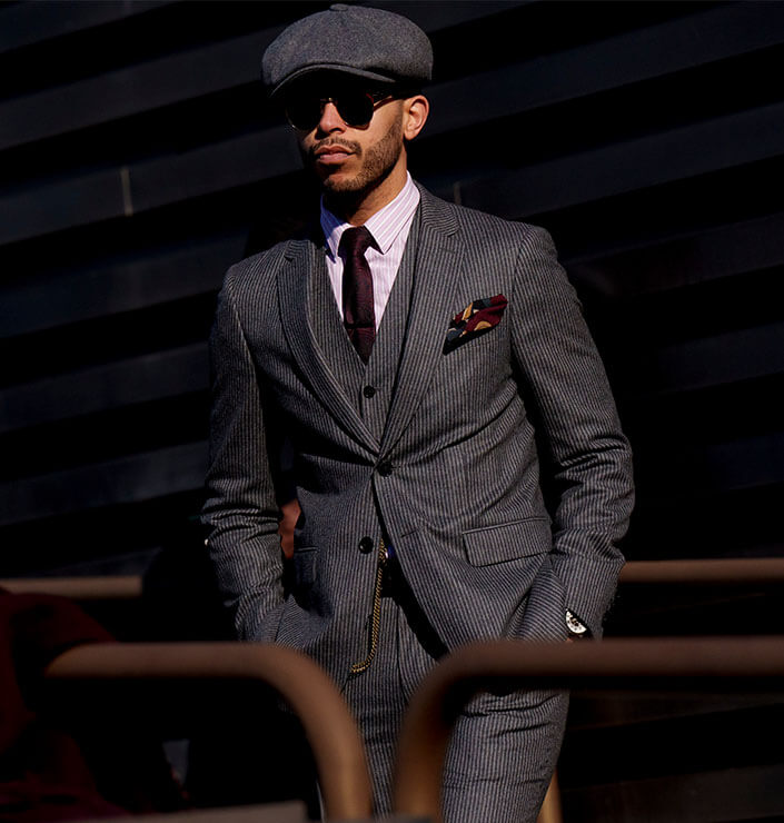 Mann mit Sonnenbrille in dunkelgrauem Anzug mit Accessoires