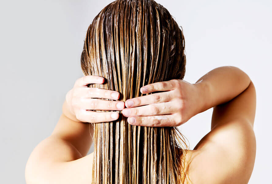 Frau mit Haaarpflegeprodukt im Haar