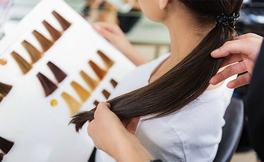 Frau mit dunkelbraunen Haaren bekommt eine Frisurenberatung