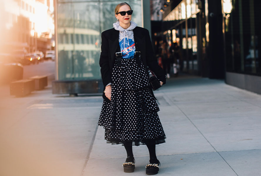 Frau in einem blauen Midi-Rock mit Punkten