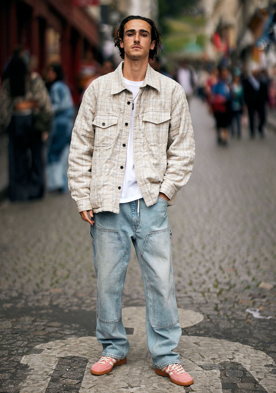 Mann trägt rosafarbene Sneaker zum Casual Outfit mit Jeans