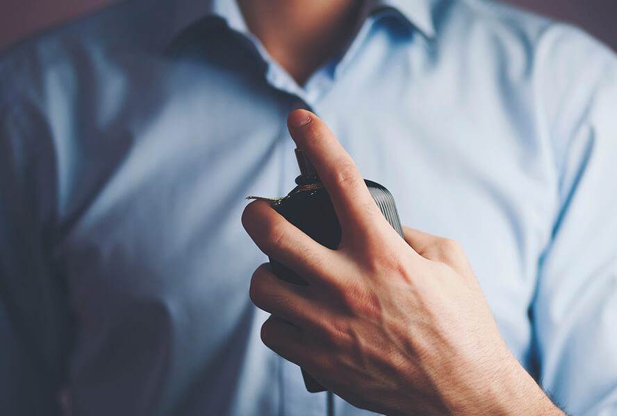 Mann mit Parfumflasche in der Hand