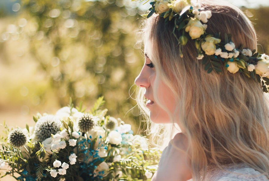 Braut mit Beach-Waves und einem Blumenkranz