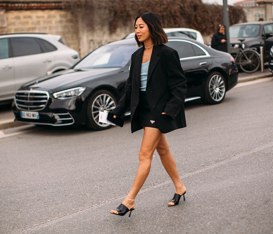 Kleine Frau in einem schwarzen Minirock und Blazer