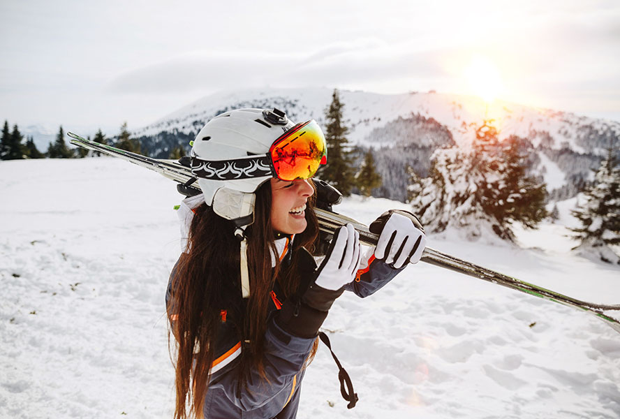 Frau trägt Skihelm auf der Piste