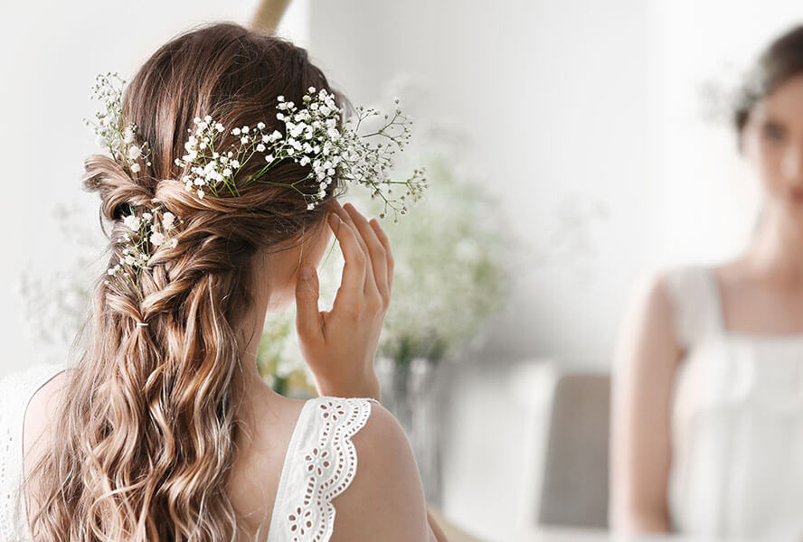 Blonde Braut mit einer halboffenen Brautfrisur, Flechtfrisur mit Blüten