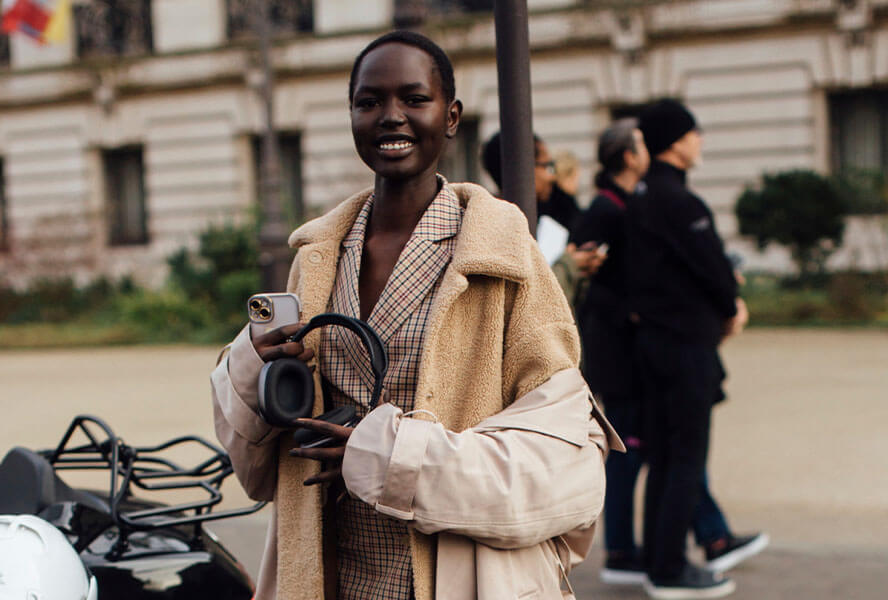 Afroamerikanische Frau mit dem Trend-Haarschnitt 2024 Buzz Cut in einem beigen Lagen-Look