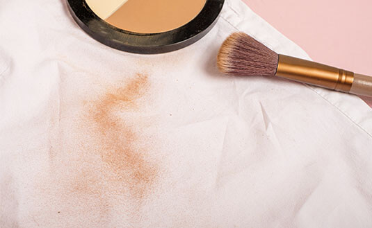 Make-up-Fleck auf einer weissen Bluse